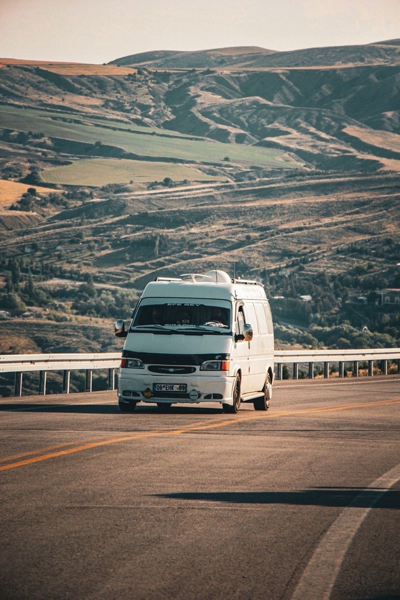 A private passenger van on a highland road, used for airport transfer routes to Bandung