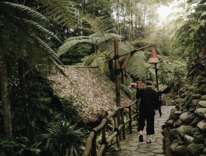Traditional bamboo huts in a forest setting, similar to Kampung Daun's dining concept near Bandung