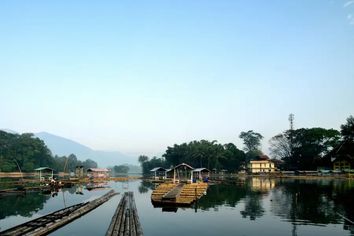 A calm lake with a small wooded island in West Java, similar to Situ Cangkuang in Garut